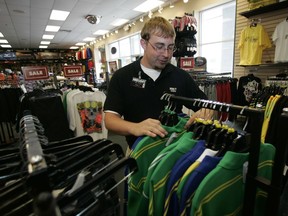 FILE - In this Wednesday, June 25, 2008, file photo, Reece Armistead, an assistant manager at Hibbett Sports in Thomasville, Ala., sorts clothing at the store. Hibbett, a chain with more than 1,000 stores, said it expects a key sales figure to fall due to a "challenging" retail environment. Hibbett's stock fell Monday, July 24, 2017, after the announcement. And shares of its competitors, such as Foot Locker and Dick's Sporting Goods, also fell. (AP Photo/Dave Martin, File)