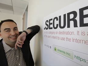 FILE - In this photo taken Friday, June 8, 2012 Alex Stamos CTO of Artemis Internet, an NCC Group Company, poses by a domain name poster at their offices in San Francisco. Some 2,000 proposals have been submitted as part of the largest expansion of the Internet address system since its creation in the 1980s. These suffixes would rival ".com" and about 250 others now in use. The organization behind it, the Internet Corporation for Assigned Names and Numbers, will announce a full list and other details in London on Wednesday, July 26, 2017. (AP Photo/Eric Risberg, File)