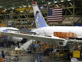In this Monday, June 12, 2017, photo, a U.S. flag is displayed above a Boeing 787 airplane being built for Norwegian Air Shuttle at Boeing Co.'s assembly facility, in Everett, Wash. The Boeing Co. reports earnings, Wednesday, July 26, 2017. (AP Photo/Ted S. Warren)