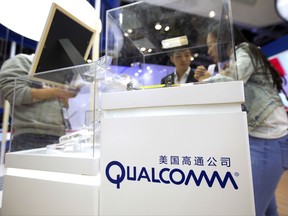 FILE - In this Thursday, April 27, 2017, file photo, visitors look at a display booth for Qualcomm at the Global Mobile Internet Conference (GMIC) in Beijing. Qualcomm is seeking to block iPhone shipments to the U.S., arguing that the phones infringe on six of its patents. Qualcomm plans to request the import ban Friday, July 7, 2017, with the U.S. International Trade Commission, which has the power to block shipments of products that violate intellectual property. However, such disputes can take a long time to resolve, so imports aren't immediately at risk. (AP Photo/Mark Schiefelbein, File)