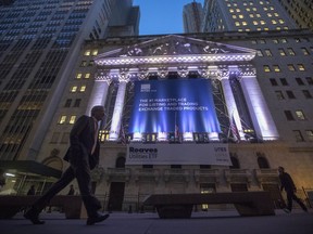 FILE - In this Tuesday, Oct. 25, 2016, file photo, a pedestrian walks past the New York Stock Exchange, in lower Manhattan.  Big gains for Facebook, Verizon Communications and other companies reporting healthier-than-expected results nudged U.S. stock indexes a bit further into record territory on Thursday, July 27, 2017 (AP Photo/Mary Altaffer, File)