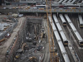 FILE - In this April 17, 2014, file photo, backhoes excavate in a hole reserved for a rail tunnel, left, during the early days of construction at the Hudson Yards redevelopment site on Manhattan's west side in New York. A concrete box was planned inside the project to preserve space for a tunnel from Newark to New York City that would allow it to double rail capacity across the Hudson River. An environmental study has been released for the Hudson River rail tunnel project, amid concerns the effort could lose key federal funding under President Donald Trump's proposed budget. (AP Photo/Bebeto Matthews, File)