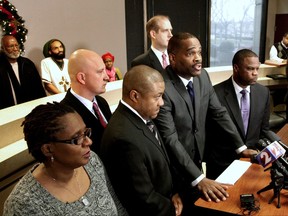 FILE – In this Dec. 16, 2014, file photo, in the front row from left to right, John Crawford III's mother Tressa Sherrod, attorney Michael Wright, Crawford's father John H. Crawford Jr. and attorney Shean Williams discuss the filing of a federal civil rights and negligence lawsuit during a news conference in Dayton, Ohio. The U.S. Justice Department said Tuesday, July 11, 2017, there was insufficient evidence to pursue charges against Sean Williams, a white police officer who fatally shot John Crawford III on Aug. 5, 2014, in a Walmart store in the Dayton suburb of Beavercreek, Ohio, as Crawford carried an air rifle picked up from a shelf. (Lisa Powell /Dayton Daily News via AP, File)