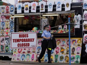 An Ohio State Highway Patrol cadet patrols the midway at the Ohio State Fair Thursday, July 27, 2017, in Columbus, Ohio. The fair opened Thursday but its amusement rides remained closed one day after Tyler Jarrell, 18, was killed and seven other people were injured when the thrill ride broke apart and flung people into the air. (AP Photo/Jay LaPrete)