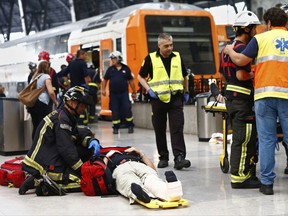 An injured passenger is attended to on the platform of a train station in Barcelona, Spain, Friday, July 28, 2017. Dozens of people were injured when a morning commuter train they were traveling on crashed into the buffers in a station in northeastern Barcelona early Friday. (AP Photo/Adrian Quiroga)