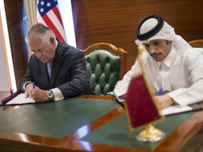 In this Tuesday July 11, 2017 photo U.S. Secretary of State Rex Tillerson, left, and the Qatari Minister of Foreign Affairs Sheikh Mohammed bin Abdulrahman Al Thani sign an memorandum of understanding  in Doha, Qatar. Tillerson arrived in Qatar as he tries to mediate a dispute between the energy-rich country and its Gulf neighbours. (Alexander W. Riedel/US State Department via AP)