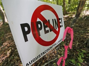FILE - In this Tuesday June 6, 2017 file photo, a No Pipeline sign is posted next to a property line marker only a few feet from the center line of the route of the proposed Atlantic Coast Pipeline in Bolar, Va. The Federal Energy Regulatory Commission, which oversees interstate natural gas pipelines, released its final environmental impact statement Friday, July 21, 2017 for the proposed 600-mile (965-kilometer) pipeline, which has broad support from political and business leaders but is staunchly opposed by environmentalists and many affected landowners. (AP Photo/Steve Helber, File)