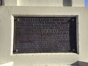This Thursday, July 20, 2017 photo, shows a plaque at the Steele Indian School Park in Phoenix, Arizona, where the former Phoenix Indian School for Native American Children used to sit. The plot of land was traded between the federal government and a private developer who was supposed to make yearslong payments to an education fund for native children. But the developer stopped making payments in 2012, and now the government has come to an agreement with the developer that allows it to skirt much of what it owes to the education fund. (AP Photo/Astrid Galvan)