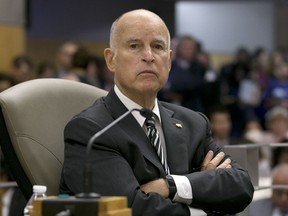 FILE -- In this July 13, 2017 file photo California Gov. Jerry Brown listens as members of the Senate Environmental Quality Committee discuss a pair of climate change bills he supports, in Sacramento, Calif. As his fourth and final term winds down Brown will spend the final 17 months in office working on California's housing crisis and fighting for ambitious projects to build a high-speed rail system and re-engineer California's water system. (AP Photo/Rich Pedroncelli, file)