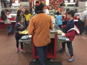 In this Thursday, May 4, 2017 photo, second grade students Angelina Lopez, left, and Nasim Hamdouni, right, enter a student account code to track lunch purchases at Gonzales Community School in Santa Fe, N.M. All students are offered the same lunch at Gonzales and other Santa Fe public schools to avoid any chance of embarrassing students whose parents may have fallen behind on meal payments. New Mexico in April became the first state to outlaw the shaming of children for any unpaid meals. (AP Photo/Morgan Lee)