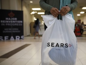 A shopper holds a Sears Canada Inc. bag for a photograph inside a mall in Toronto, Ontario, Canada, on Thursday, June 22, 2017. Canadian retailer Sears Canada Inc. is seeking creditor protection as it works to restructure the business. Sears Canada Inc., the struggling offshoot of Sears Holdings Corp., filed for protection from creditors after running short on shoppers and cash.