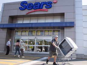 Bargain hunters are seen at the Sears store in Quebec as liquidation sales began Friday.