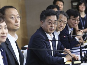 South Korean Finance Minister Kim Dong-yeon, center, speaks during a press conference at the government complex in Seoul, South Korea, Tuesday, July 25, 2017. South Korea's new administration is shifting gears to achieve a fair and labor-friendly economy after decades of growth led by big businesses left many behind in economic prosperity. (AP Photo/Ahn Young-joon)