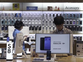 In this Wednesday, July 26, 2017 photo, a visitor experiences Samsung Electronics Galaxy S8 smartphones at its shop in Seoul, South Korea. Samsung Electronics on Thursday, July 27, said its second-quarter profit surged 85 percent to record high thanks to memory chips. (AP Photo/Ahn Young-joon)