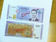 In this photo released by the Syrian official news agency SANA, the new bank note of 2,000 Syrian Lira, (