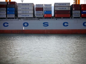 FILE - In this Sept. 11, 2009 file photo, a ship is loaded with containers for COSCO, China Ocean Shipping (Group) Company, at a container terminal in the port of Dalian, China. Shares in both China's state-owned shipping company, COSCO, and Orient Overseas (International) Ltd. have surged after COSCO agreed to buy its smaller rival for $6.3 billion.  The merger will create a new Asian shipping giant. It is part of a wave of consolidation in global shipping that has produced a handful of huge global competitors. By mid-afternoon Monday, July 10, 2017, COSCO's shares traded in Hong Kong had jumped 6.1 percent while Orient Overseas shares soared 20.8 percent. (AP Photo/Elizabeth Dalziel, File)