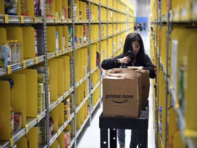 A staff member collects merchandise for customers' orders from shelves at the newly-opened Amazon Prime Now facility in Singapore Thursday, July 27, 2017. Amazon introduced express delivery in Singapore in its first direct effort to win over Southeast Asian digital natives and new internet users. The American e-commerce company announced Thursday it will begin operating a 100,000 square foot (9,290 square meter) distribution facility in the wealthy island nation. (AP Photo/Joseph Nair)