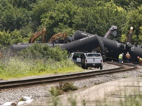 FILE - In this July 1, 2017 file photo, cleanup and containment continues, following the derailment of 20 Canadian National railroad tankers in Plainfield, Ill. Most roads have reopened in Plainfield after the train carrying crude oil derailed about 40 miles southwest of Chicago. Plainfield police say it will take several days to clean up the oil near the village's downtown business district. (Daniel White/Daily Herald via AP, File)