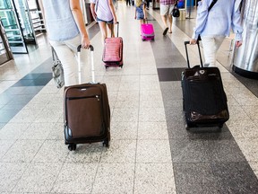 Travelers pull luggage while walking through LaGuardia Airport (LGA) in New York, U.S., on Thursday, June 29, 2017. The Trump administration provided details of its revised†travelban†on refugees and on visitors from six majority Muslim countries hours before it's to take effect, seeking to ensure thereís no repeat of the chaotic scenes at airports when the order was initially imposed in January.