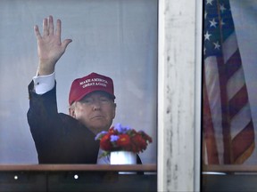 President Donald Trump waves to spectators as he watches the third round of the U.S. Women's Open Golf tournament from his observation booth, Saturday, July 15, 2017, in Bedminster, N.J. (AP Photo/Seth Wenig)