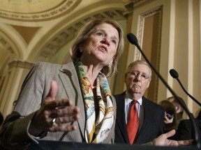 FILE - In this Jan. 20, 2015 file photo, Sen. Shelley Moore Capito, R-W.Va., accompanied by Senate Majority Leader Mitch McConnell of Ky., speaks during a news conference on Capitol Hill in Washington. West Virginia likes to say it's "Almost Heaven." Less idyllic is the spot its Republican senator, Shelley Moore Capito, is in as she decides whether to back her party's effort to bulldoze Democrat Barack Obama's health care law. (AP Photo/J. Scott Applewhite, File)