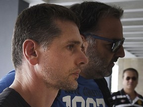 A Russian man is escorted by police officers as he arrives at a courthouse at the northern Greek city of Thessaloniki, Wednesday, July 26, 2017. Greek authorities say they have arrested a Russian man wanted in the United States on suspicion of masterminding a money laundering operation involving at least $4 billion through bitcoin transactions. (AP Photo/Giannis Papanikos)