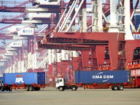 Trucks move shipping containers at a port in Qingdao in eastern China's Shandong Province, Thursday, July 13, 2017. Growth in China's exports and imports accelerated for a second month in June in a positive sign for global demand and the country's own economy. (Chinatopix via AP)