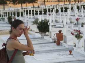 A woman cries by the graves of soldiers killed in the 1974 Turkish invasion of Cyprus in the Tymvos Macedonitissas military cemetery, during the 43rd anniversary in the divided capital of Nicosia, Cyprus, Wednesday, July 19, 2017. Greek and Cypriot soldiers were killed in 1974 during the Turkish invasion and subsequent occupation of the northern part of the island of Cyprus. Cyprus was split into Greek Cypriot south and Turkish Cypriot north in 1974 when Turkey invaded in response to a coup by supporters of union with Greece. (AP Photo/Petros Karadjias)