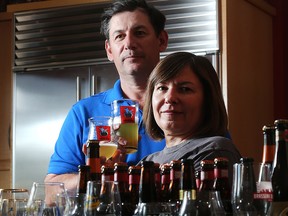 Mike Tessier and partner Bo Vitanov hold glasses of Trou du Diable, a beer they import from Shawinigan, Quebec, in their Calgary home Monday June 27, 2016.