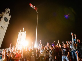 Spectators at Montreal's Jacques Cartier bridge raise their cellphones to add volume to the festivities with their AmpMe app.