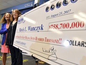 Mavis Wanczyk, of Chicopee, Mass., stands by a poster of her winnings during a news conference where she claimed the $758.7 million Powerball prize at Massachusetts State Lottery headquarters, Thursday, Aug. 24, 2017, in Braintree, Mass.