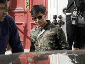 In this April 5, 2017, photo, Vorayuth "Boss" Yoovidhya, whose grandfather co-founded energy drink company Red Bull, walks to get in a car as he leaves a house in London. Interpol on Monday, Aug. 28, 2017, issued an international request for the arrest of the billionaire heir to the Red Bull energy drink fortune, stepping up the hunt for the fugitive Thai playboy wanted in allegedly killing of a traffic policeman in a 2012 hit-and-run incident in Bangkok. (AP Photo/Matt Dunham)