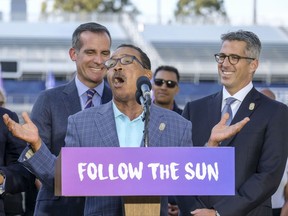 Los Angeles Mayor Eric Garcetti, left, and L.A. Olympic Committee leader Casey Wasserman, right, react as City Council President Herb Wesson speaks during a press conference to make an announcement for the city to host the Olympic Games and Paralympic Games 2028, at StudHub Center in Carson, outside of Los Angeles, Calif., Monday, July 31, 2017. (AP Photo/Ringo H.W. Chiu)
