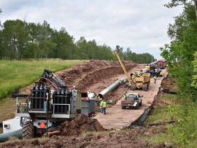 In this July 25, 2017, photo provided by Wisconsin Public Radio, crews begin work on the Wisconsin segment of Enbridge Energy's Line 3 near Superior, Wis. Six activists were arrested Tuesday, Aug. 29, for obstructing the work, and more protests are planned this weekend. (Elizabeth McMahon/Wisconsin Public Radio via AP)