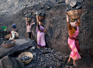 Baskets of coal scavenged illegally are carried at a mine in a village in the eastern Indian state of Jharkhand.