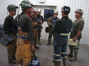 FILE - In this Aug. 28, 2009, file photo, coal miners receive a safety briefing at Signal Peak Energy's Bull Mountain coal mine near Roundup, Mont. A judge has blocked a proposed 176-million ton expansion of the mine because federal officials did not consider its climate change impacts. (AP Photo/Matthew Brown, File)