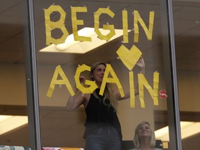 Office workers put up a new sign in support of pop singer Taylor Swift at the end of the civil trial involving the pop singer in a case in federal court Monday, Aug. 14, 2017, in Denver. (AP Photo/David Zalubowski)