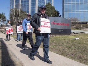Striking journalists walk outside the Chronicle Herald building in Halifax on Thursday, April 13, 2017. The Halifax Chronicle-Herald and the union representing the paper's striking newsroom workers have reached a tentative agreement to end their 18-month-old labour dispute. THE CANADIAN PRESS/Andrew Vaughan
