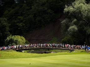 Spectators cross the bridge between the 13th and 14th holes during the Canadian Open golf tournament at Glen Abbey golf club, in Oakville, Ont., on Saturday, July 29, 2017. Glen Abbey, one of Canada's most famous golf courses, could be a step closer to receiving some protection from potential redevelopment into a residential and commercial complex after a town council meeting this week. THE CANADIAN PRESS/Nathan Denette
