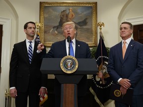 President Donald Trump, flanked by Sen. Tom Cotton, R- Ark., left, and Sen. David Perdue, R-Ga., speaks in the Roosevelt Room of the White House in Washington, Wednesday, Aug. 2, 2017, during the unveiling of legislation that would place new limits on legal immigration. (AP Photo/Evan Vucci)