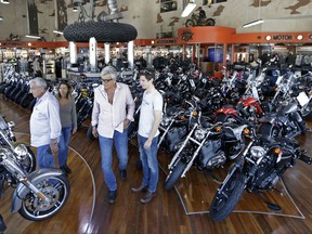 In this Tuesday, April 25, 2017, photo, customers look at Harley-Davidson motorcycles in the showroom at a dealership in Miami. On Tuesday, Aug. 15, 2017, the Commerce Department reports on business stockpiles in June. (AP Photo/Alan Diaz)