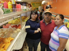 In this June 27, 2017 photo, from left, Diana Resendiz, Alberto Resendiz, and Maribel Resendiz, pose for a photo at their business Mr. Tutis Fruties in Florida City, Fl. Maribel Resendiz and her husband came to the U.S. from Mexico, sold cool drinks to workers in the tomato fields of South Florida and eventually opened a bustling shop in a strip mall offering fruit smoothies and tacos. Now she is preparing for the possibility she'll have to leave it all behind. (AP Photo/Lynne Sladky)