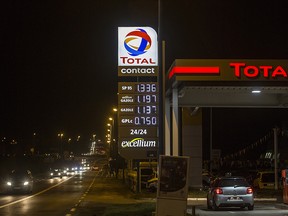 Fuel prices sit illuminated on a sign as an automobile stands beside petrol pumps on the forecourt of a gas station operated by Total SA, at night in Luc-La-Primaube near Rodez, France, on Saturday, Dec. 12, 2015.