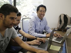 In this Friday, July 14, 2017, photo, computer scientist Andrew Ng, right, works with others at his office in Palo Alto, Calif. Ng, one of the world's most renowned researchers in machine learning and artificial intelligence, is facing a dilemma: there aren't enough experts trained to train the machines. So when he isn't pushing into the frontier of AI himself, Ng is building new ways to help educate the next generation of AI specialists. (AP Photo/Eric Risberg)