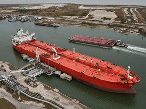 The tanker Eagle Seville discharges crude oil, front, while a barge passes by at the Port of Corpus Christi in Corpus Christi, Texas, U.S., as seen in this aerial photo taken on Monday, Dec. 27, 2010.