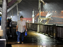 Rogelio Ortiz makes his way off the Pirate's Landing Fishing Pier as rain from Hurricane Harvey falls on Thursday