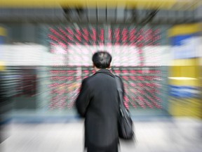 A Japanese businessman gazes at a share prices board in downtown Tokyo