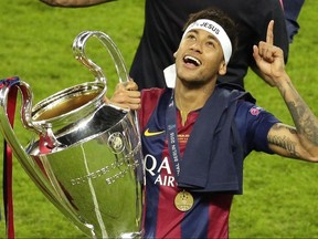FILE - In this Saturday, June 6, 2015 file photo, Barcelona's Neymar celebrates with the trophy after the Champions League final soccer match between Juventus Turin and FC Barcelona at the Olympic stadium in Berlin. Barcelona said, Wednesday, Aug. 2, 2017, Neymar's 222 million euro ($262 million) release clause must be paid in full if the Brazil striker wants to leave. (AP Photo/Michael Sohn, File)