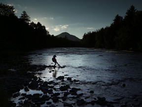 In this Tuesday, Aug. 8, 2017 photo, a youngster explores the Penobscot River's East Branch at the new Katahdin Woods and Waters National Monument near Patten, Maine. Interior Secretary Ryan Zinke wants to retain the newly created national monument, but said he might recommend adjustments to the White House on Thursday, Aug. 24, 2017. (AP Photo/Robert F. Bukaty)