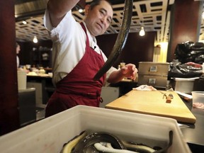 In this Thursday, July 20, 2017 photo, chef Masa Miyake prepares to clean and cook eels at his Japanese restaurant, in Portland, Maine. Miyake is one of a growing number of restaurants that serve Maine farm-raised eels. (AP Photo/Robert F. Bukaty)